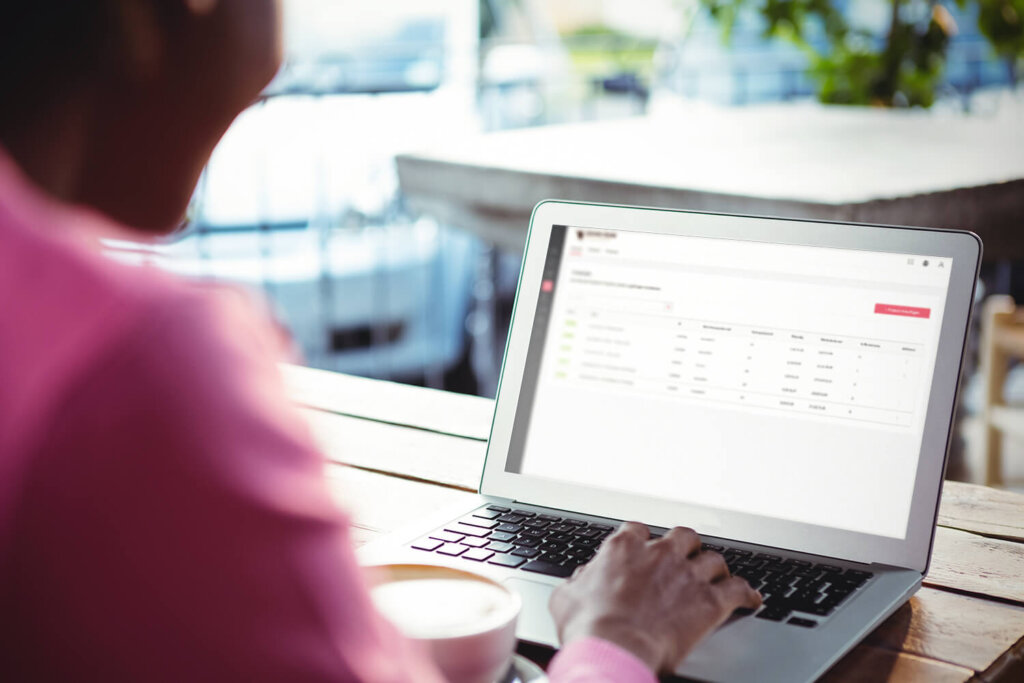 Auf dem Bild ist eine Person zu sehen, die an einem Schreibtisch sitzt und an ihrem Laptop arbeitet. Auf dem Bildschirm ist das Cloud-Programm von nexnet zu sehen, mit welchem Unternehmen ihr Subscription Billing erledigen können.